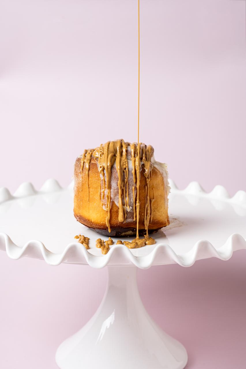 Glazed sweet roll on a white cake stand