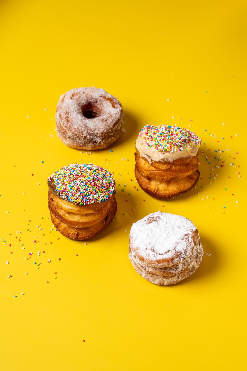 Sugar and sprinkle doughnuts on a yellow background