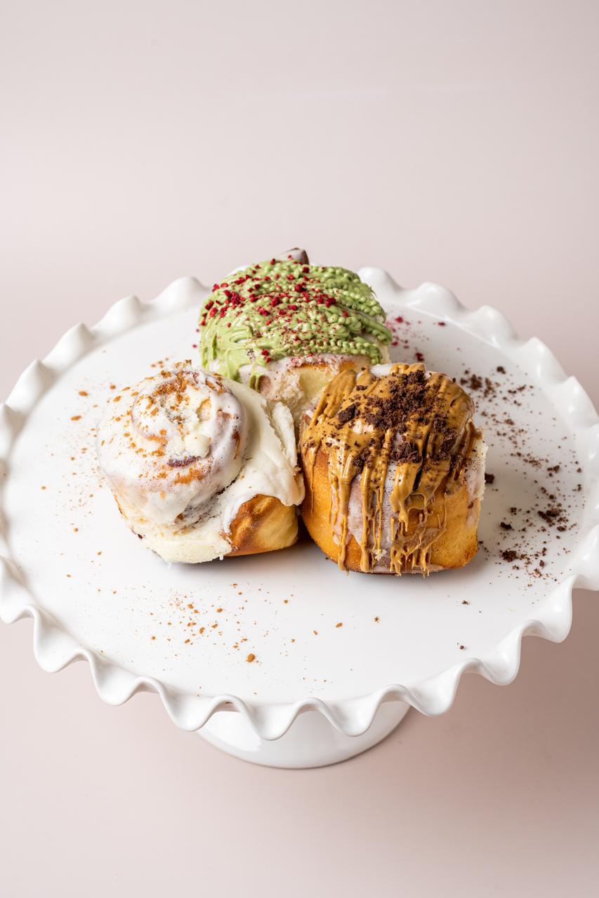 Three sweet rolls with pistachio, cream and caramel toppings